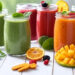 Home Detox Smoothies, Colorful assortment of home detox smoothies in glass jars with fresh fruits and vegetables